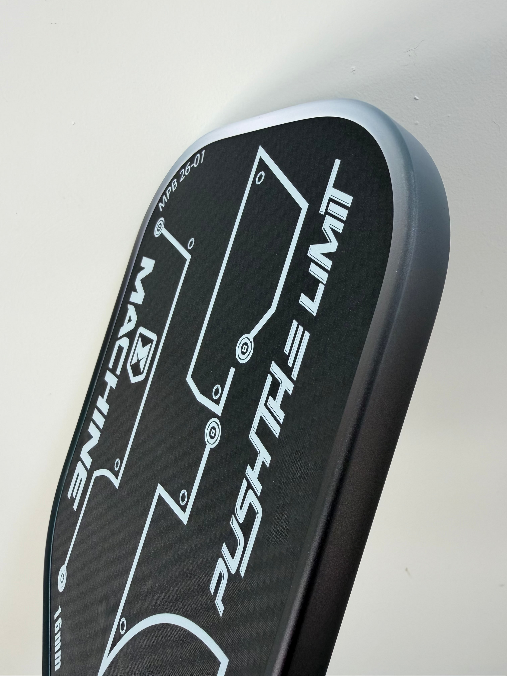 Close-up of a black and gray car spoiler with 'Machine' and 'Push the Limit' branding on a light gray background.