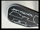 Close-up of a black and silver golf club head with branding on a light gray background